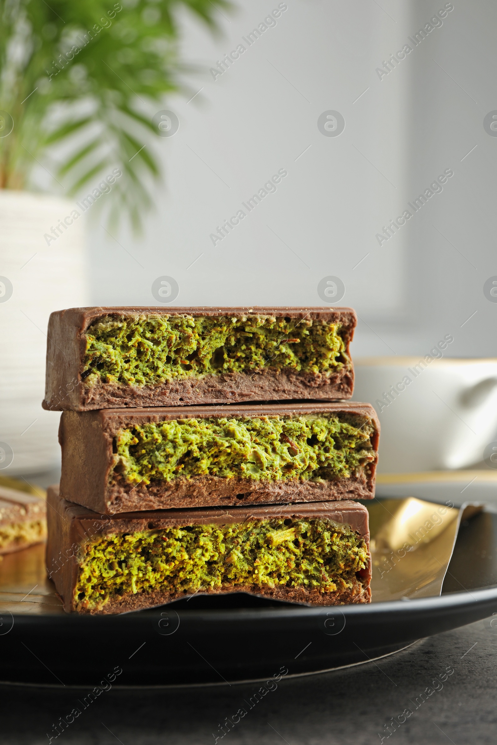Pieces of delicious Dubai chocolate with pistachios and knafeh on table, closeup Photo of Pieces of delicious Dubai chocolate with pistachios and knafeh on table, closeup