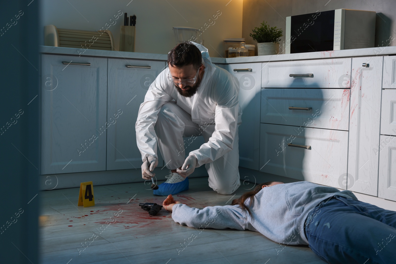 Photo of Forensic expert taking fingerprints with brush from gun and dead body at crime scene indoors