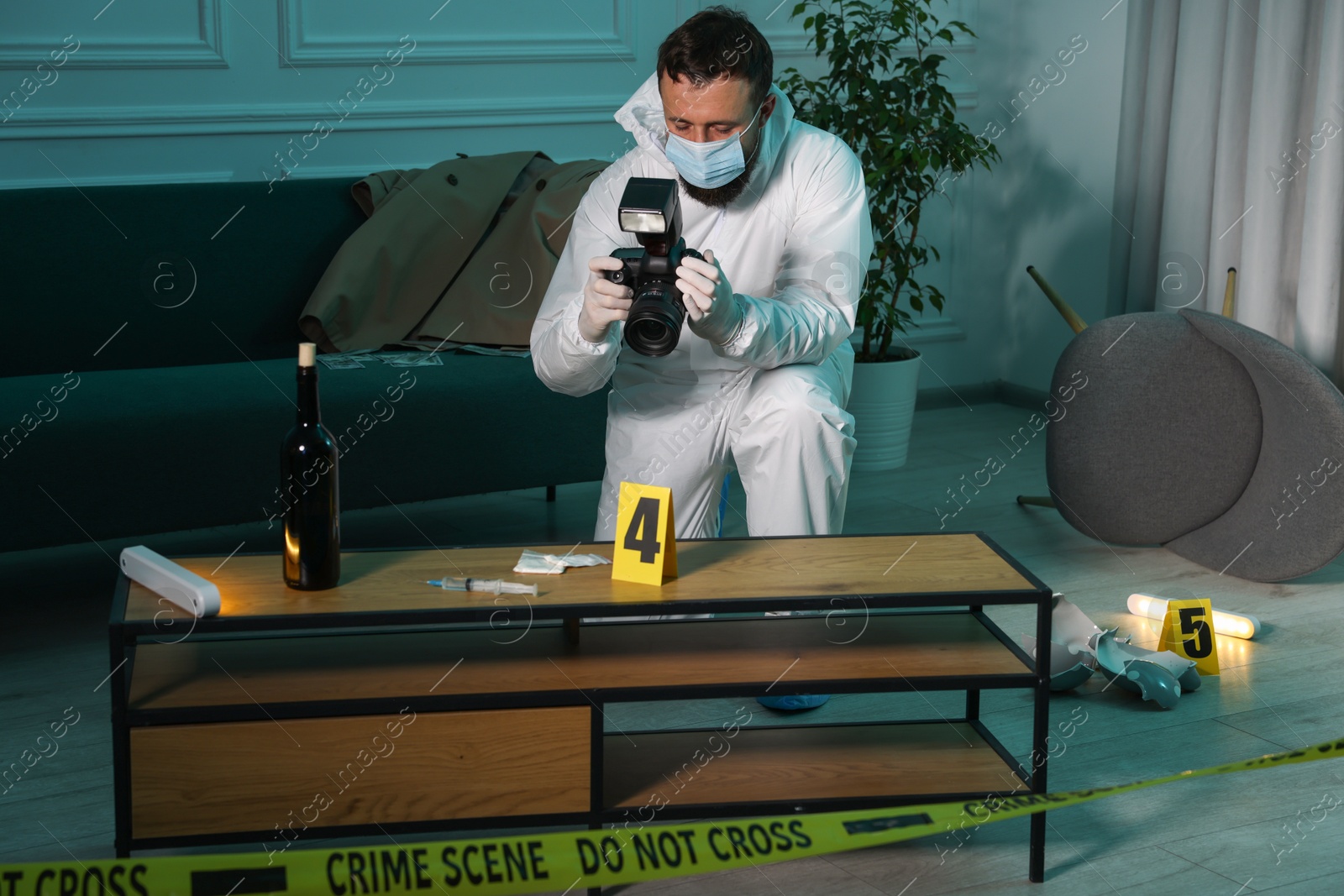 Photo of Forensic expert with camera taking photo of evidences at crime scene indoors