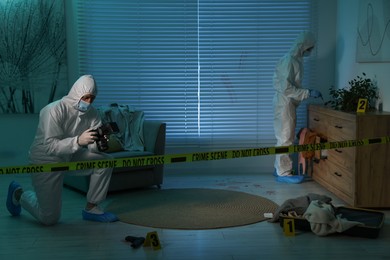 Forensic experts working at crime scene indoors