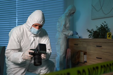 Photo of Forensic experts working at crime scene indoors