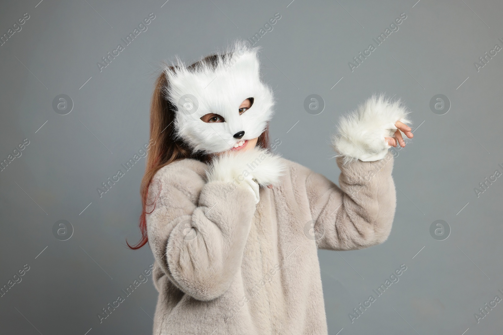 Photo of Quadrobics. Girl wearing cat mask and gloves on grey background