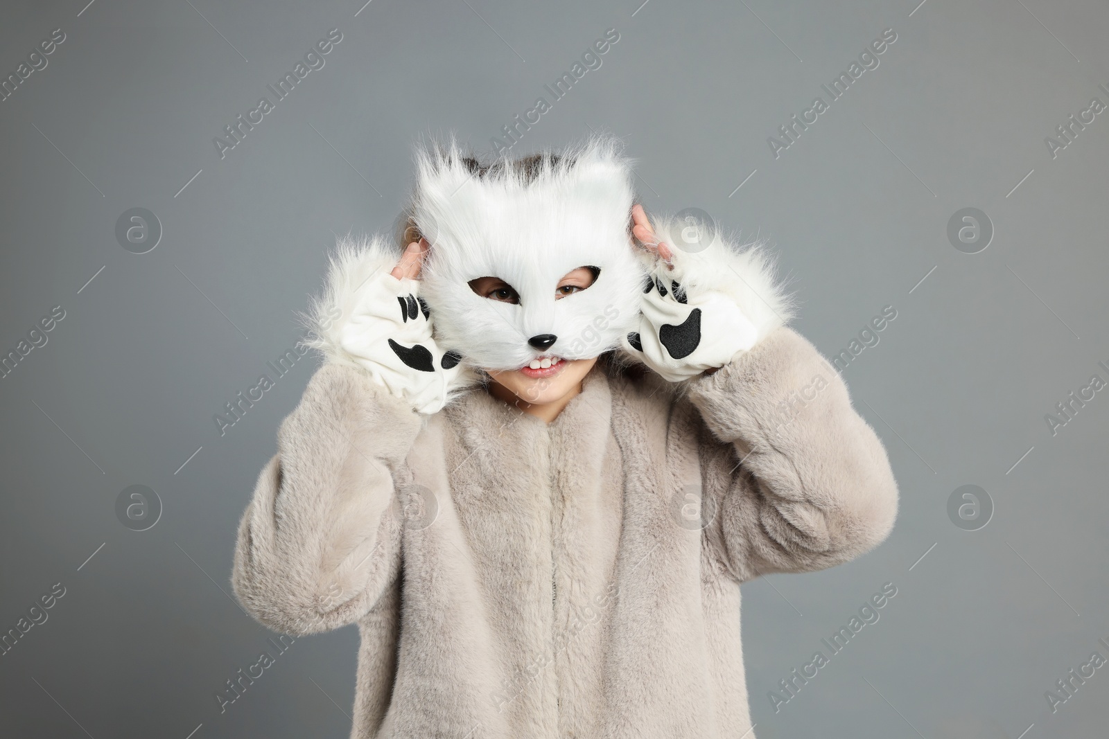 Photo of Quadrobics. Girl wearing cat mask and gloves on grey background