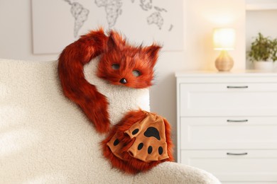 Photo of Quadrobics. Fox mask, gloves and tail on armchair indoors, space for text