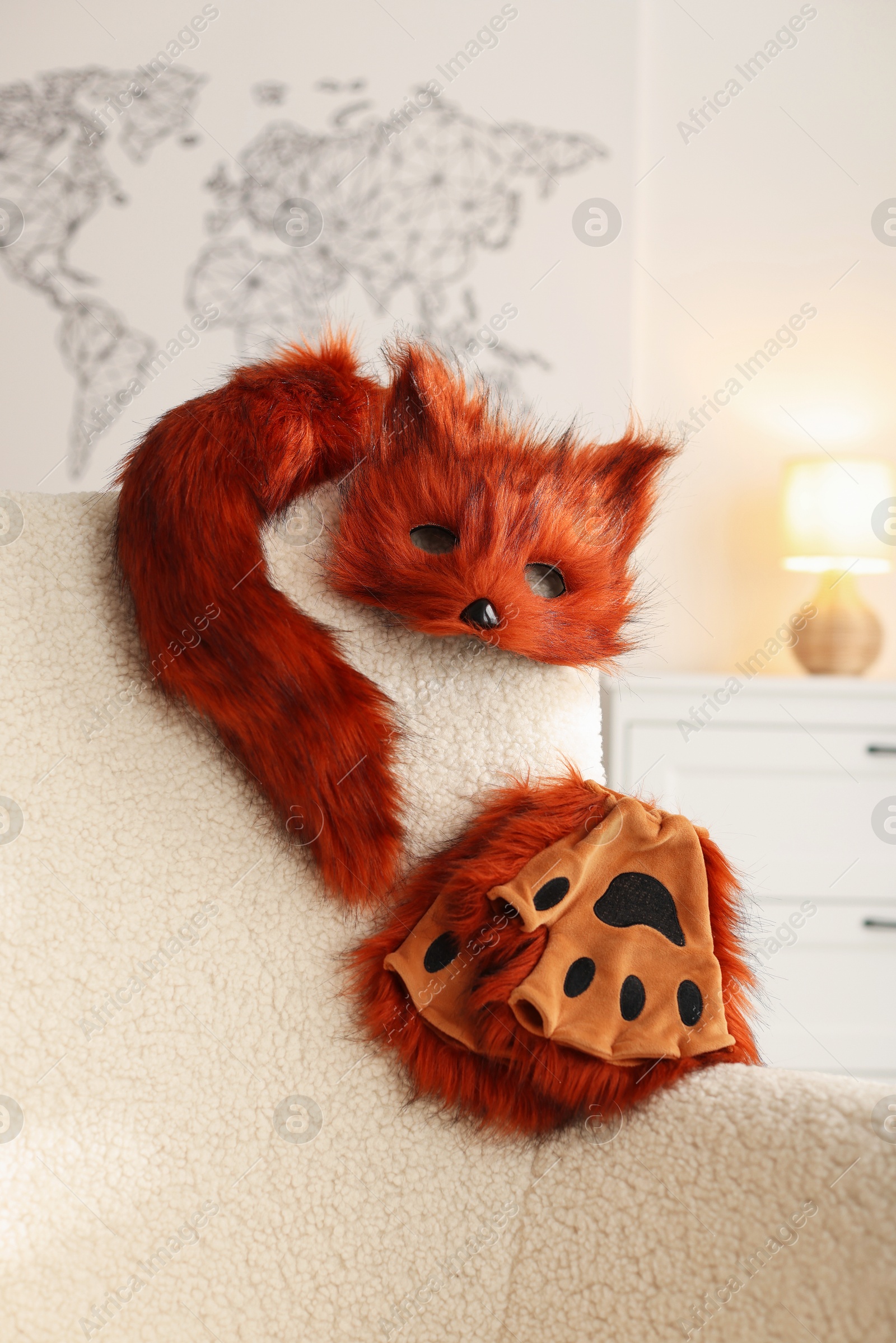 Photo of Quadrobics. Fox mask, gloves and tail on armchair indoors