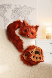 Photo of Quadrobics. Fox mask, gloves and tail on armchair indoors