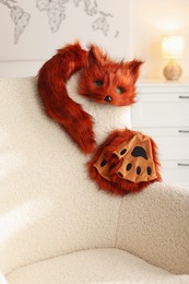 Photo of Quadrobics. Fox mask, gloves and tail on armchair indoors