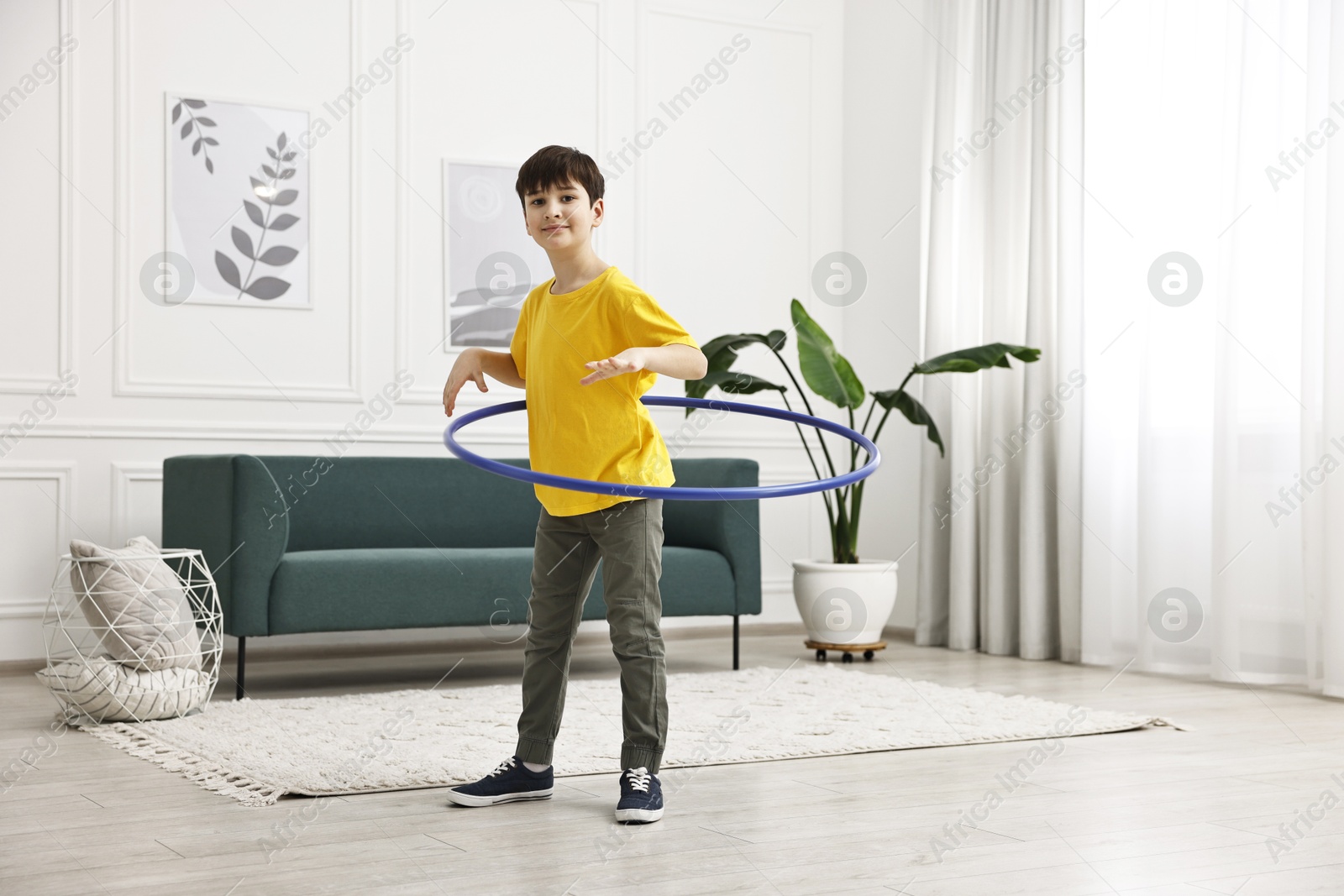 Photo of Boy exercising with hula hoop at home