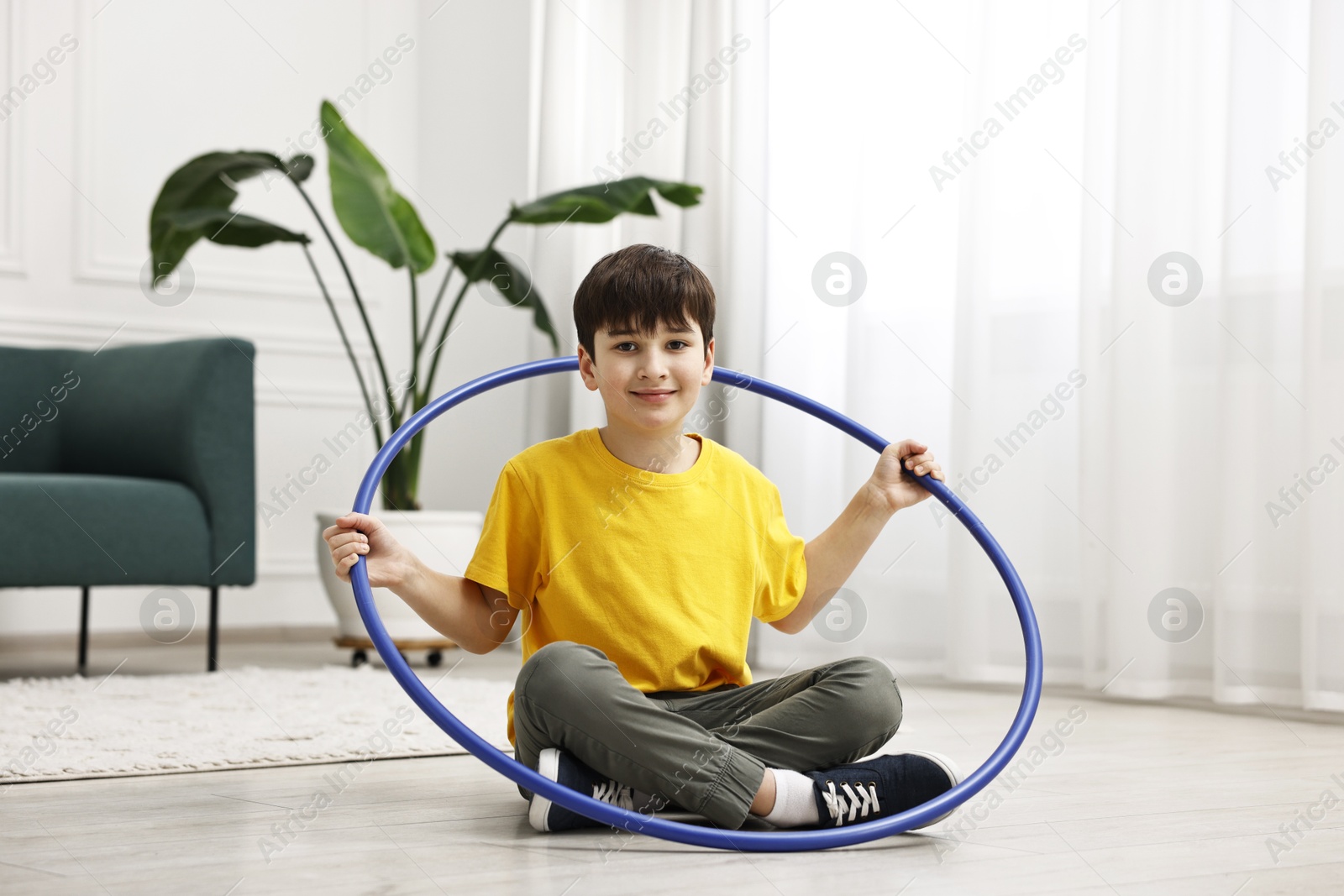 Photo of Boy with hula hoop on floor at home