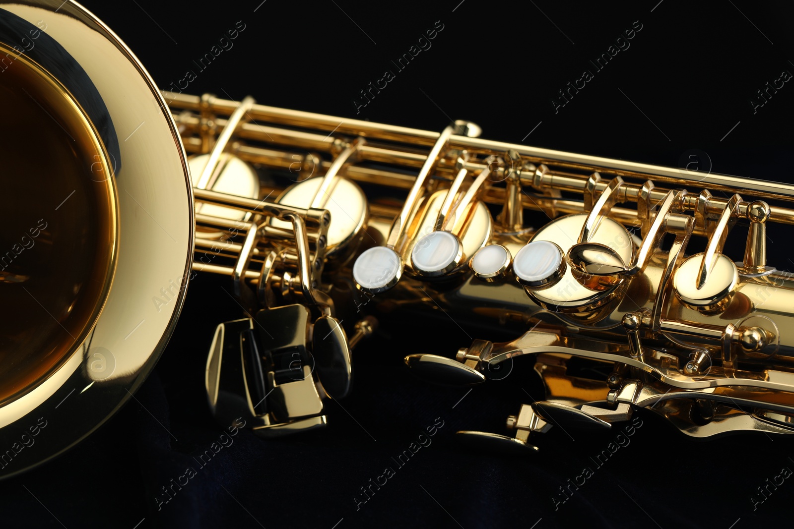 Photo of Jazz. One beautiful saxophone on black background, closeup