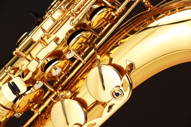 Photo of Jazz. One beautiful saxophone on black background, closeup