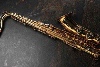 Photo of Jazz. One saxophone on black textured table, top view