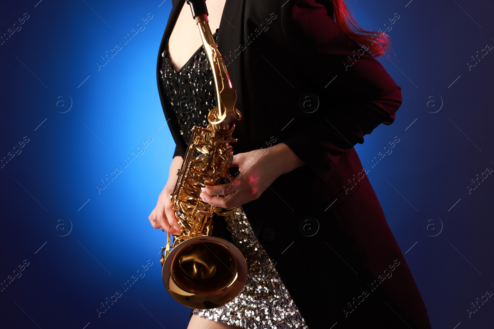 Photo of Professional musician with saxophone on color background, closeup