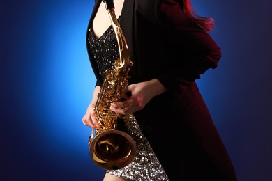 Photo of Professional musician with saxophone on color background, closeup