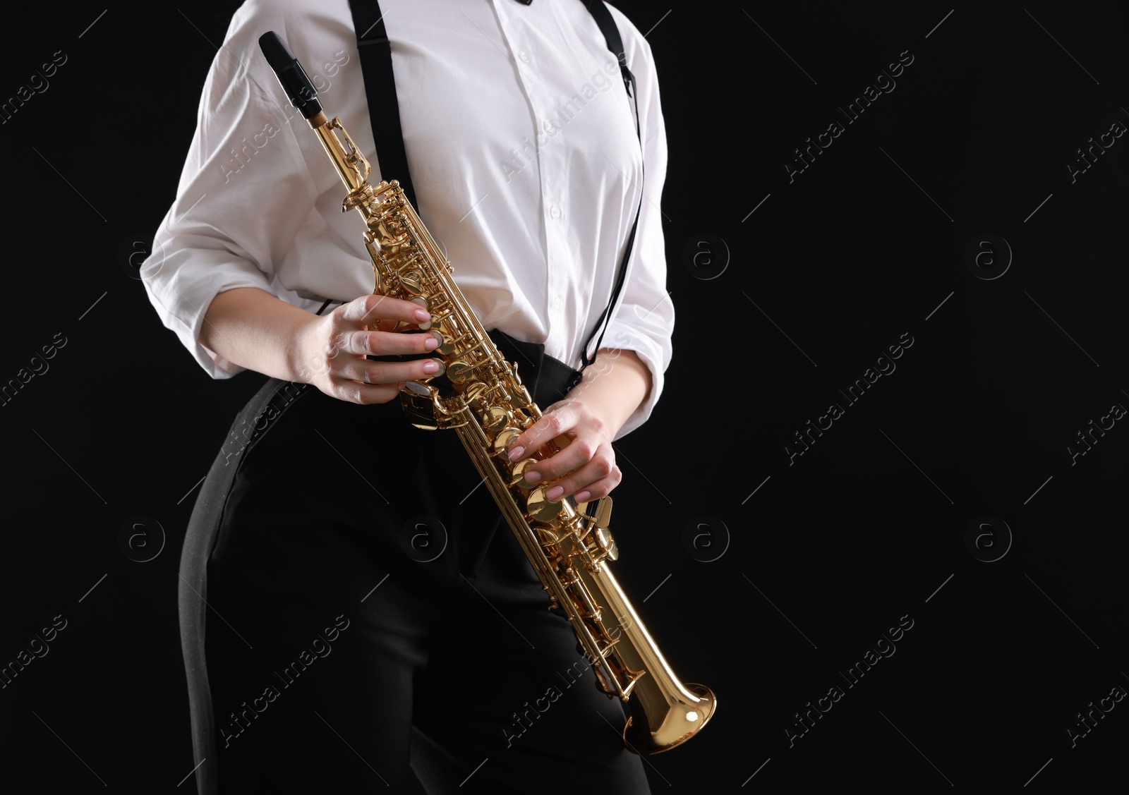 Photo of Musician with soprano saxophone on dark background, closeup. Space for text