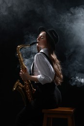 Photo of Professional musician playing saxophone on dark background with smoke