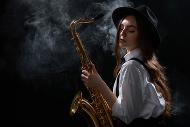 Photo of Professional musician playing saxophone on dark background with smoke