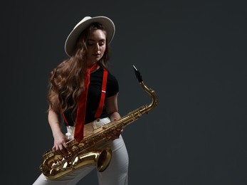 Photo of Professional musician with saxophone on grey background. Space for text