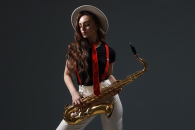 Photo of Professional musician with saxophone on grey background