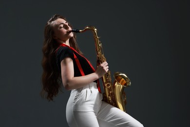 Photo of Professional musician playing saxophone on grey background