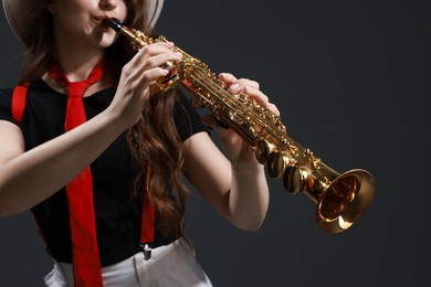 Photo of Musician playing soprano saxophone on grey background