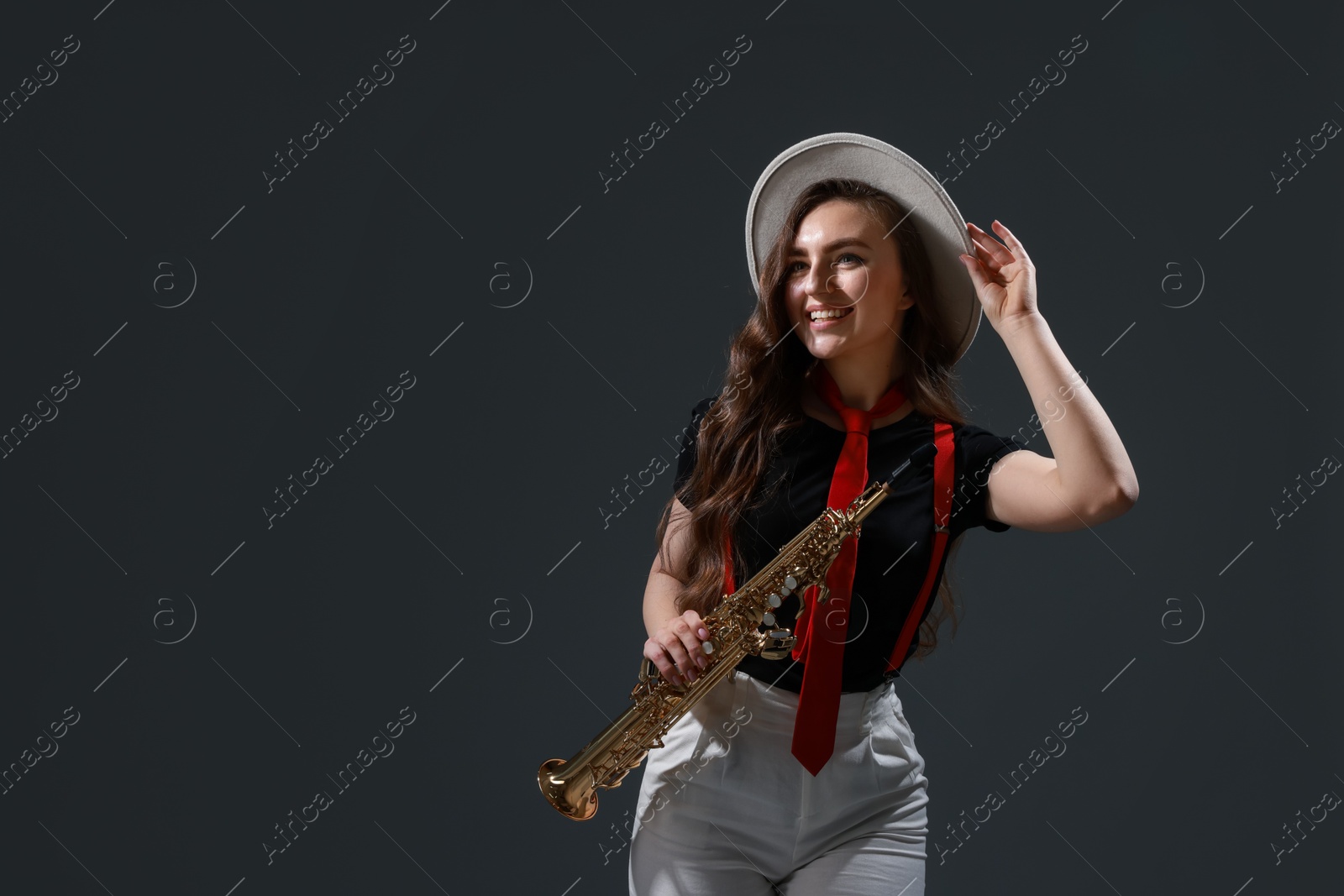 Photo of Musician playing soprano saxophone on grey background. Space for text