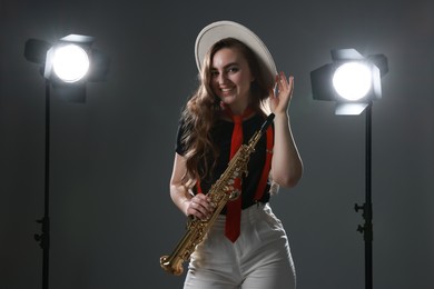 Musician with soprano saxophone on grey background