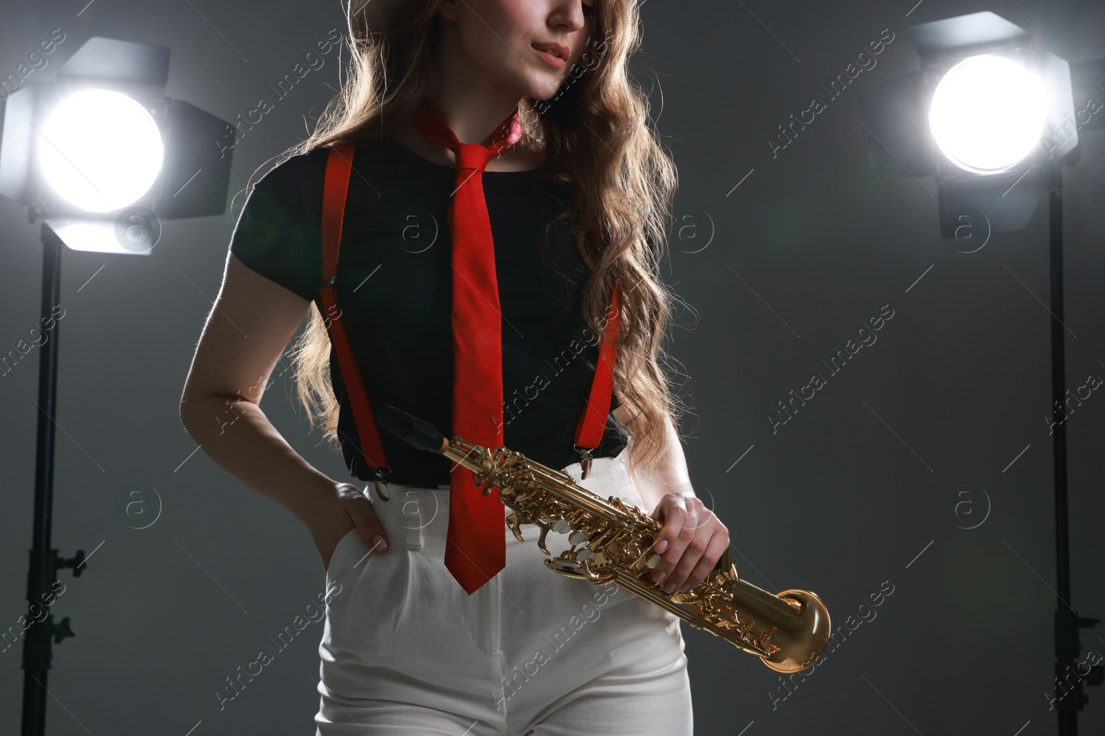 Photo of Musician with soprano saxophone on grey background, closeup