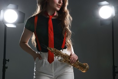 Photo of Musician with soprano saxophone on grey background, closeup