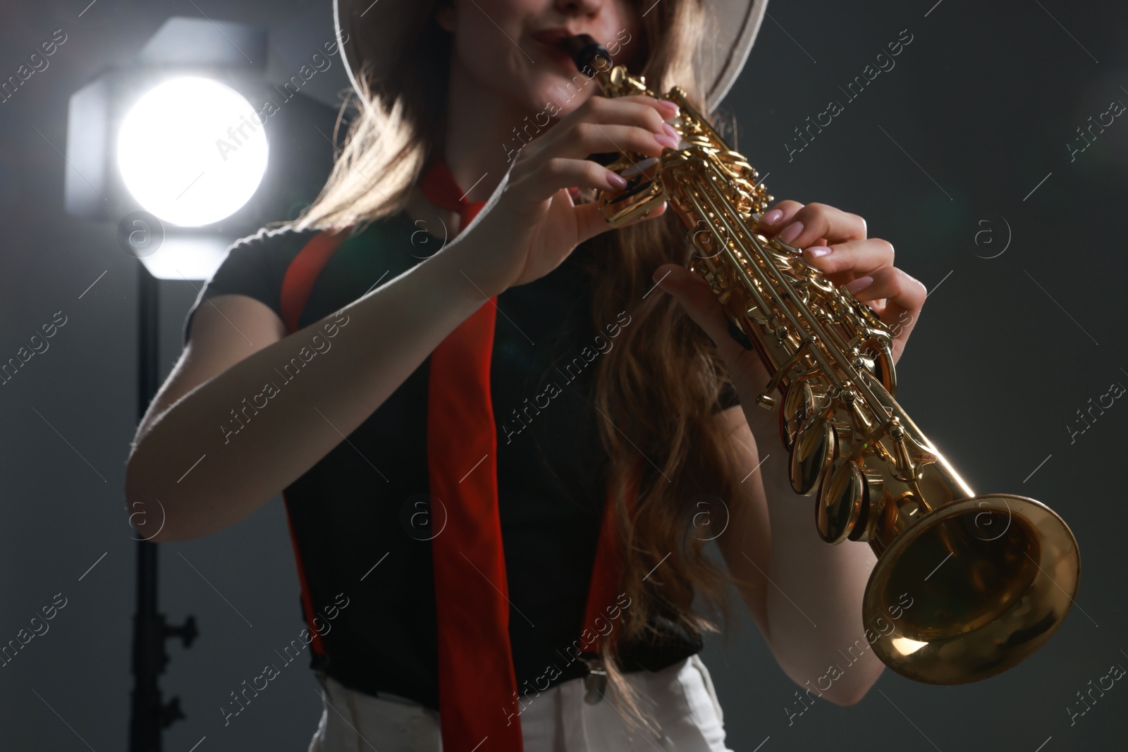 Photo of Musician playing soprano saxophone on grey background, closeup