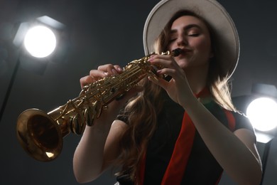 Photo of Musician playing soprano saxophone on grey background, closeup