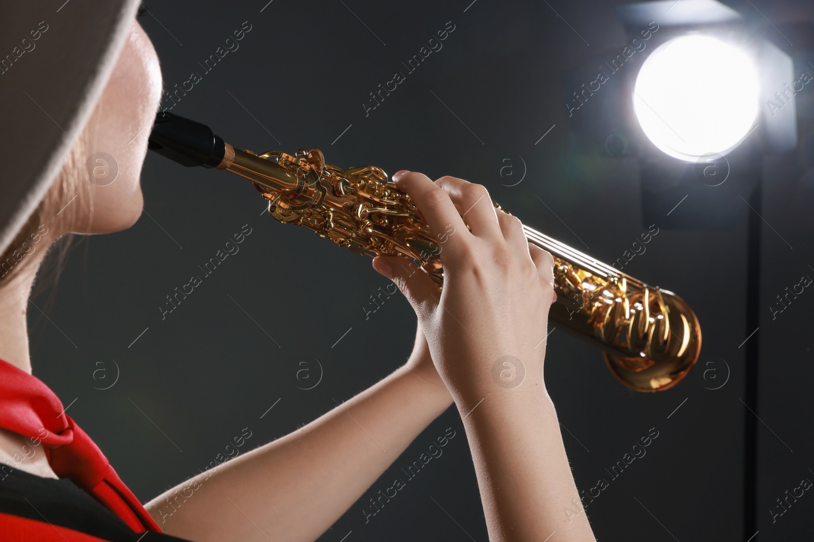 Photo of Musician playing soprano saxophone on grey background, closeup