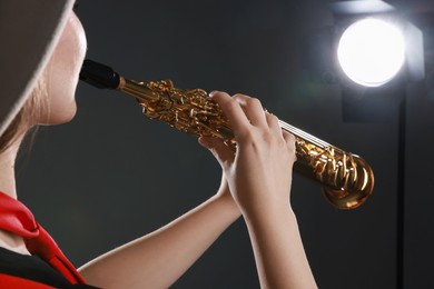 Musician playing soprano saxophone on grey background, closeup