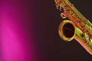 Photo of Golden saxophone on color background, closeup. Space for text