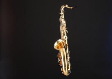 Photo of Golden saxophone on black background. Musical instrument