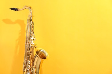 Photo of Golden saxophone on yellow background. Space for text