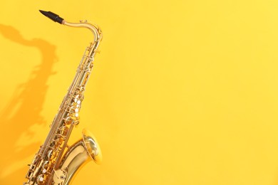 Photo of Golden saxophone on yellow background. Space for text