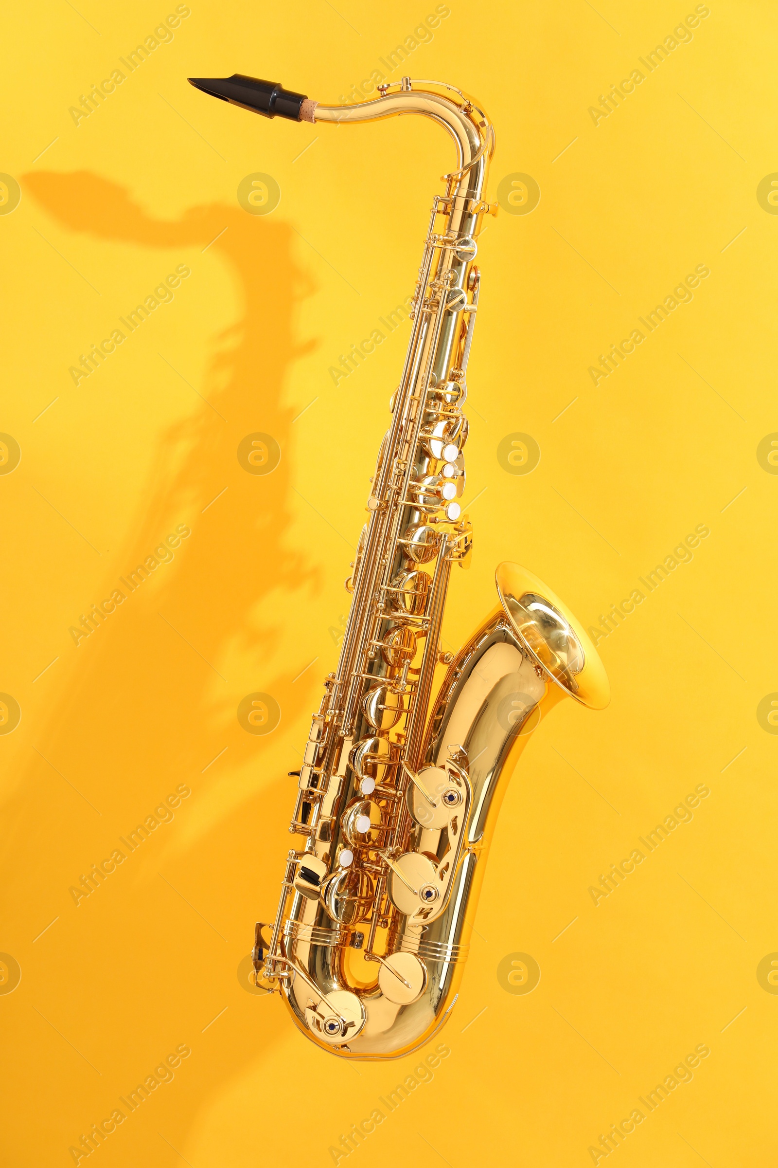 Photo of Golden saxophone on yellow background. Musical instrument