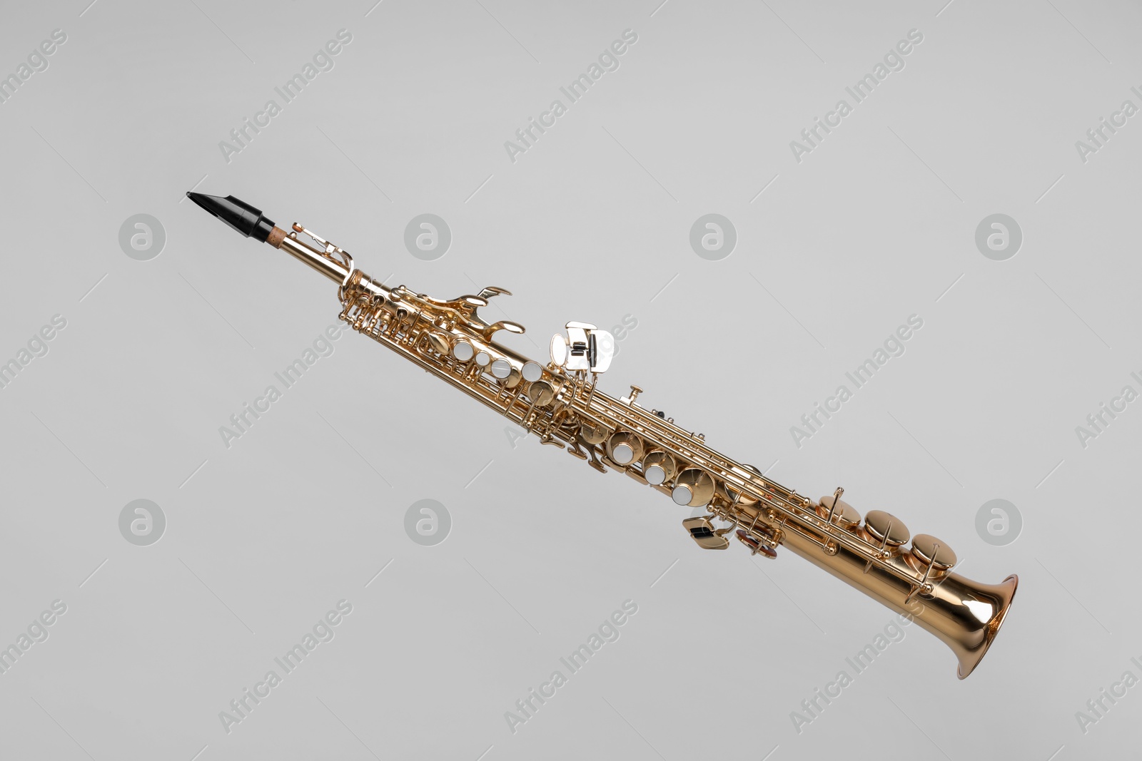 Photo of Golden soprano saxophone on light grey background