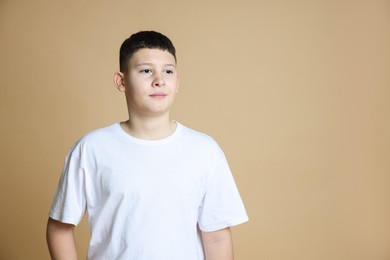 Photo of Portrait of teenage boy on beige background, space for text