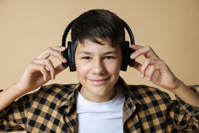 Photo of Portrait of teenage boy in headphones on beige background