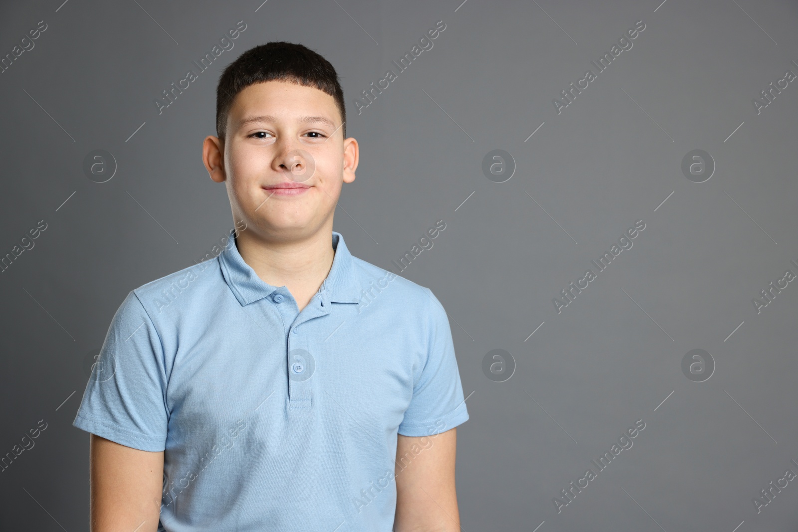 Photo of Portrait of teenage boy on grey background, space for text