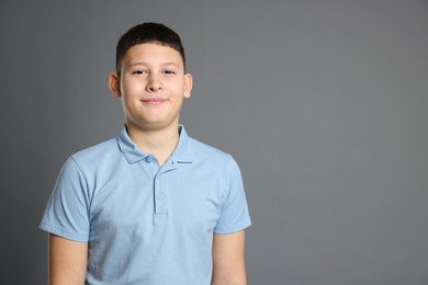 Photo of Portrait of teenage boy on grey background, space for text