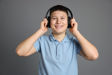 Photo of Portrait of teenage boy in headphones on grey background