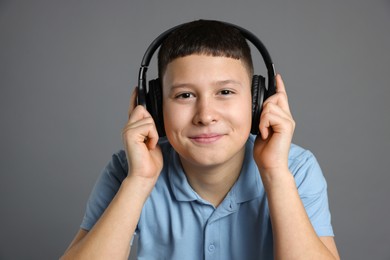 Photo of Portrait of teenage boy in headphones on grey background