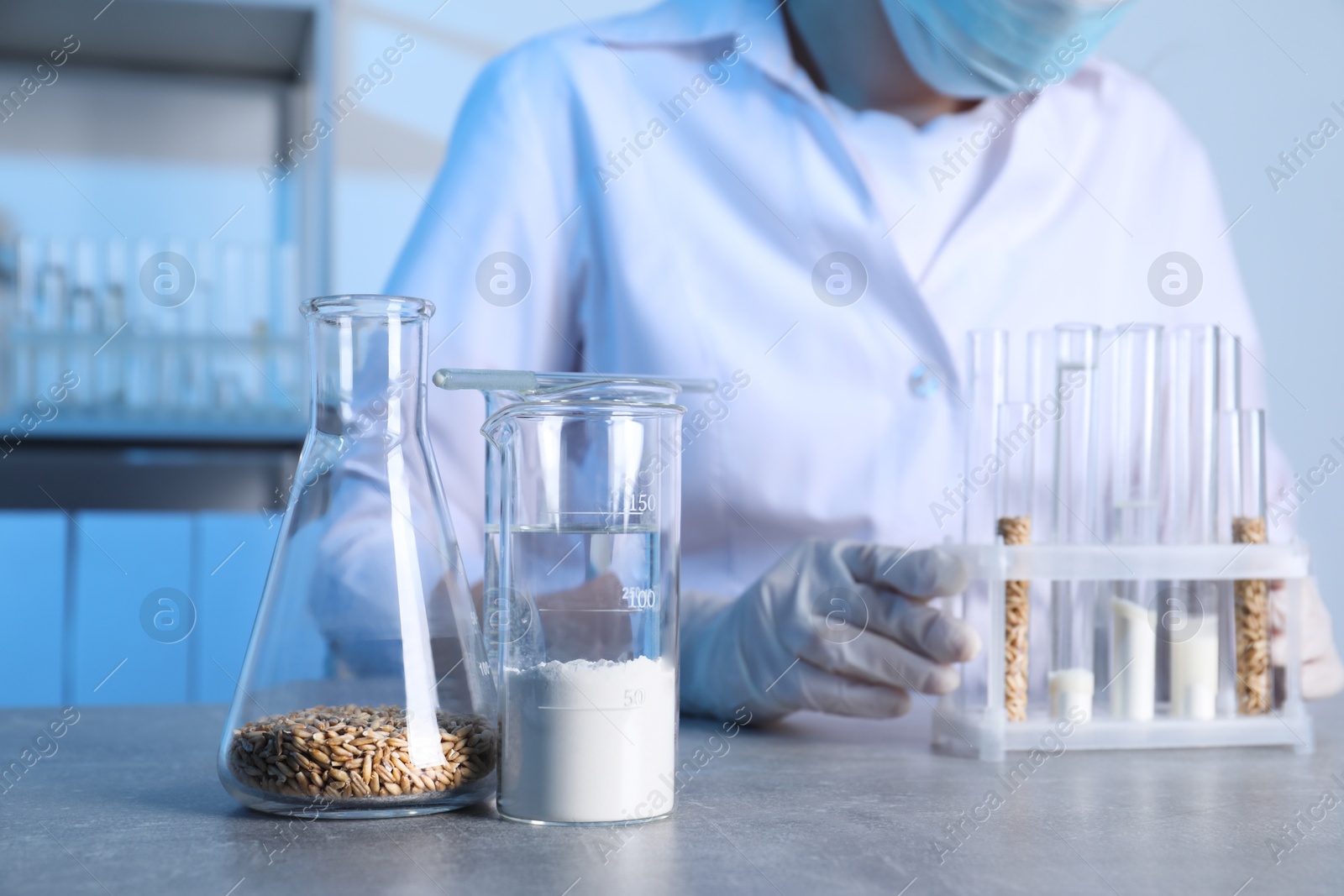 Photo of Laboratory testing. Scientist with test tubes at table indoors, focus on glassware of samples