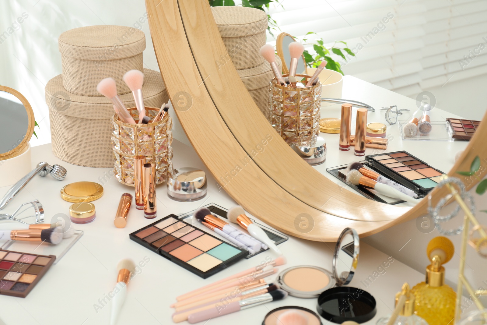 Photo of Makeup room. Dressing table with mirror and different beauty products indoors, closeup