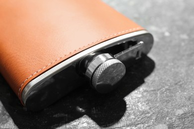 Photo of One hip flask on dark table, closeup