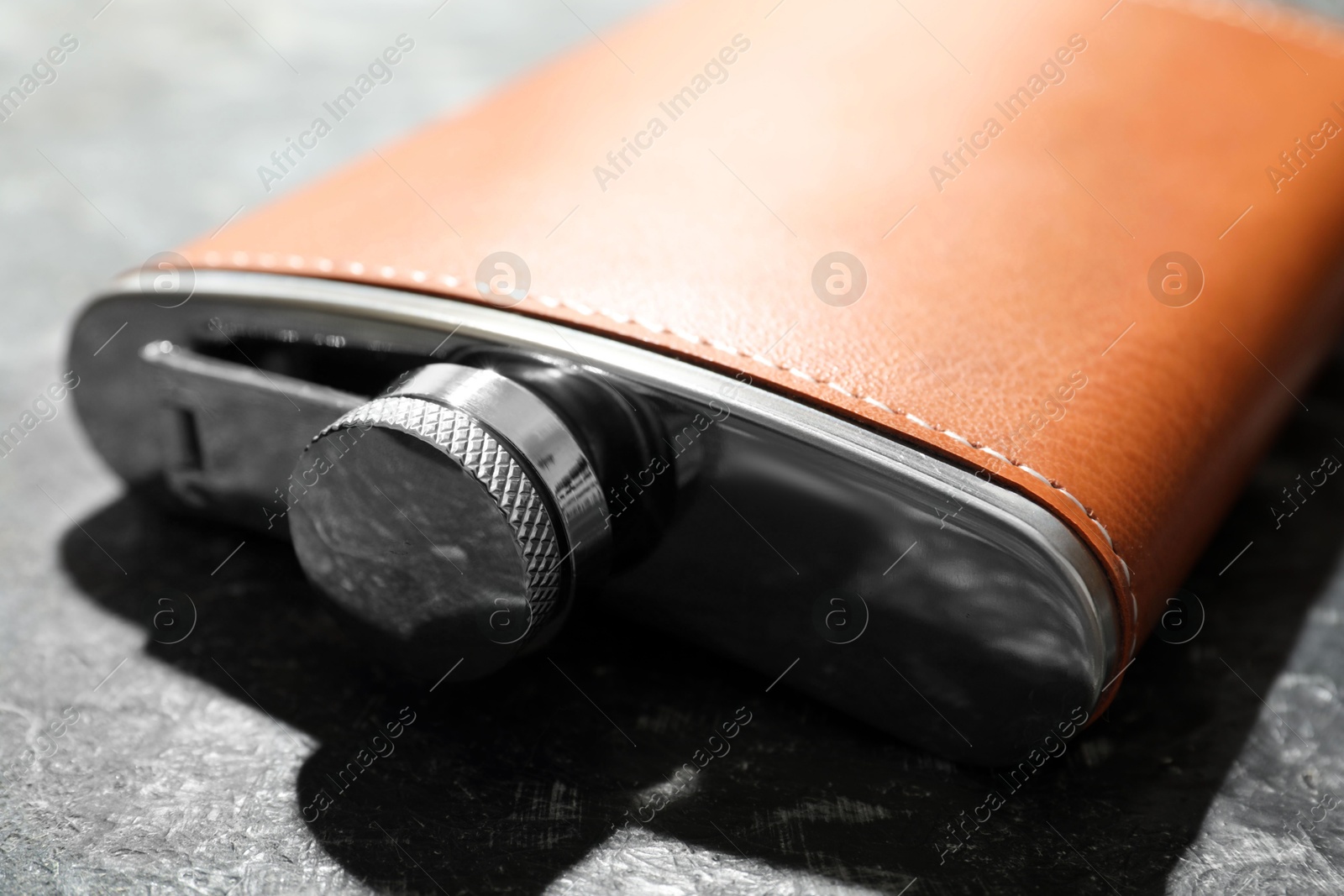 Photo of One hip flask on dark table, closeup