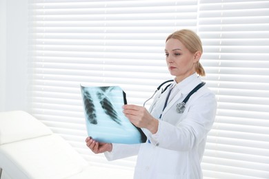 Photo of Doctor examining x-ray image of lungs in clinic